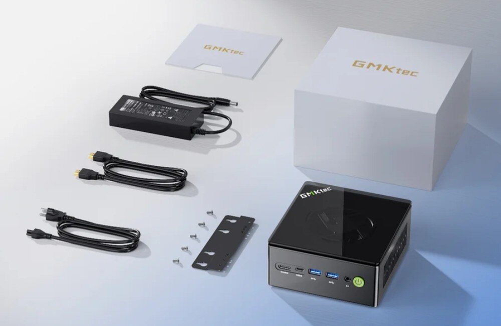 Komputer GMKTEC K8 Plus Zestaw elementów znajdujących się w pudełku z komputerem mini PC: urządzenie, zasilacz, przewody, uchwyt montażowy, śruby i opakowanie z logo producenta