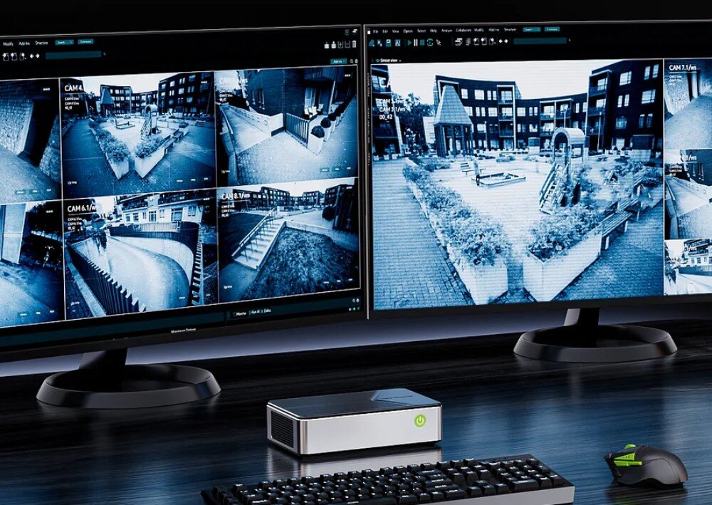 Komputer GMKTEC G9 Dwa monitory z wyświetlonym podglądem z kamer monitoringu osiedla, a pod nimi mini komputer, klawiatura i mysz, obudowa, wielkość, uchwyt VESA