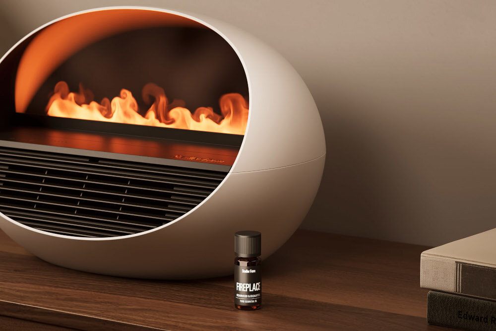 Na drewnianym blacie stoi biały termowentylator o owalnym kształcie z widocznym efektem płomieni wewnątrz. Obok znajduje się mała buteleczka z napisem \'FIREPLACE\'.