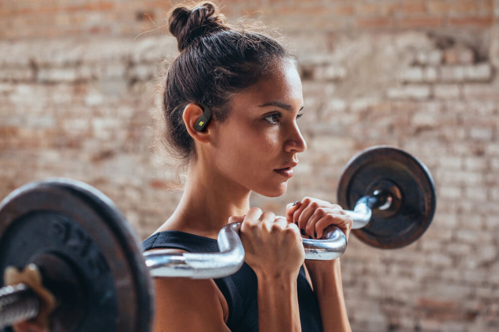 JBL Endurance Zone Cztery mikrofony formowanie wiązki redukcja szumów, osoba z założonymi słuchawkami ćwiczaca na siłowni