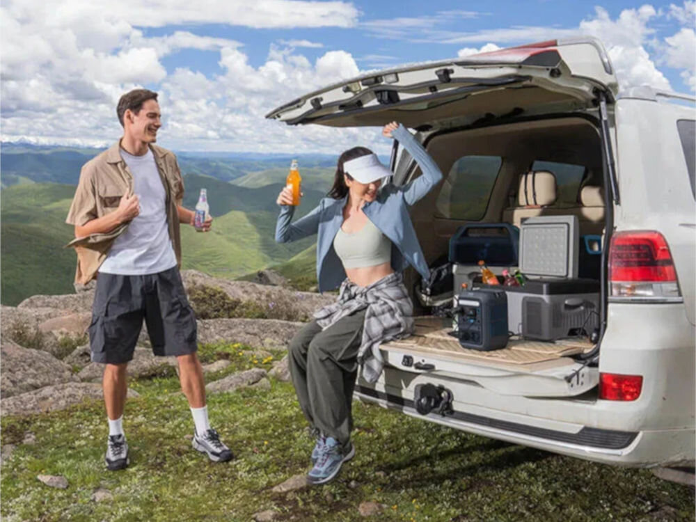 Stacja zasilania ANKER Solix C300X 288 Wh Bank energii + Panel solarny PS60 60W, zasilanie, prąd, energia, panel, słońce, para odpoczywa na bagażniku auta na którym stoi stacja zasilania