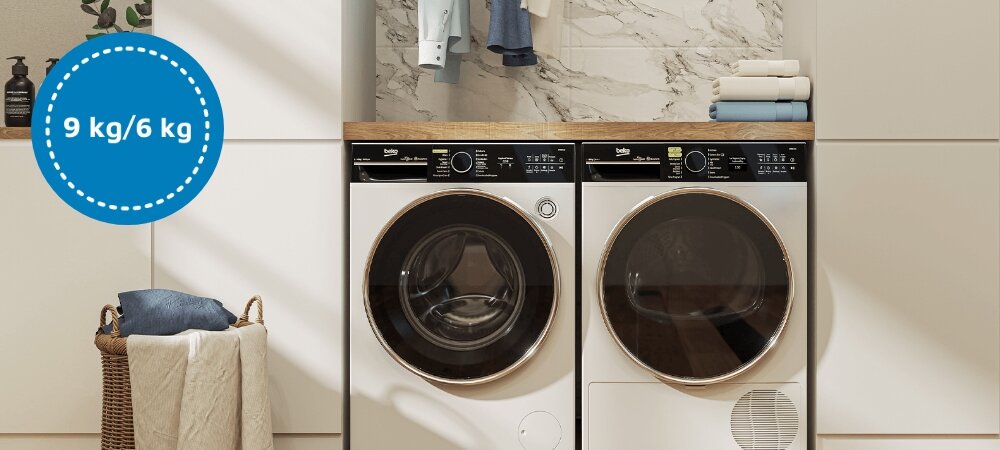 PRALKO-SUSZARKA BEKO bPRO500 BM5DFT6944WP 6.jpg przedstawia estetyczną pralnię z ustawionym obok siebie zestawem pralka–suszarka w zabudowie, z drewnianym blatem i jasną, minimalistyczną aranżacją. Po lewej stronie, nad wiklinowym koszem z ręcznikami, znajduje się niebieskie kółko z białym napisem „9 kg/6 kg”, informujące o maksymalnym wsadzie prania i suszenia urządzenia pojemność 9 kg pranie 6 kg suszenie pralko‑suszarka BEKO małe gospodarstwo domowe wygodne pranie oszczędność czasu i energii