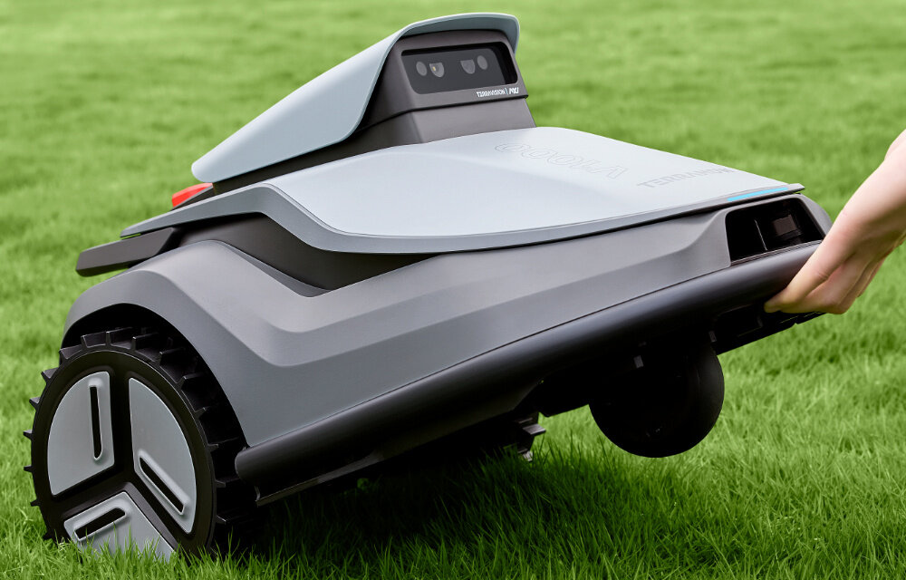 Robot koszący TERRAMOW V1000 trawnik robot na trawniku osoba trzyma przód robota w dłoni automatyczne koszenie koszenie bez ograniczeń technologia AI technologia 3D
