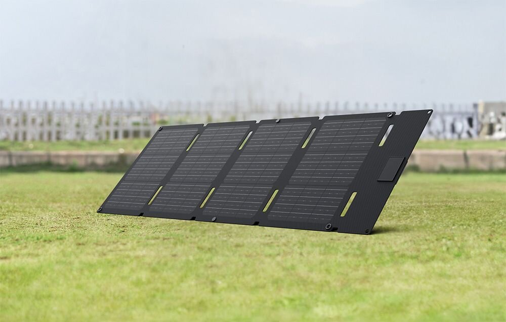 Panel fotowoltaiczny ECOFLOW 45W (USB-C), gniazdo, przewód, telefon, laptop, Przenośny panel solarny rozłożony na trawie.