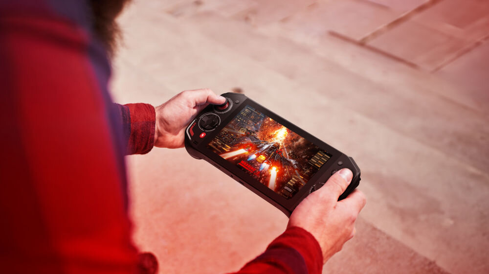 Konsola ACER Nitro Blaze 7 Czarny prezentacja urządzenia podczas korzystania osoba trzymająca w dłoniach konsole w tle chodnik 7-calowy dotykowy ekran FHD odświeżanie płynny obraz AMD FreeSync™ Premium redukcja zacięć