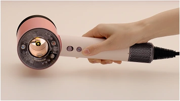 Zbliżenie na suszarkę unoszoną z blatu za rączkę.