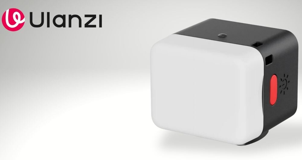 Kompaktowa lampa LED z białym frontem i czarną obudową, z czerwonym przyciskiem z boku. Logo Ulanzi widoczne w lewym górnym rogu.