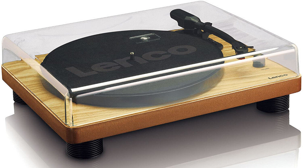 Gramofon z drewnianą podstawą i przezroczystą pokrywą, na której widnieje napis \'Lenco\'. Urządzenie posiada czarny talerz i ramię do odtwarzania płyt.