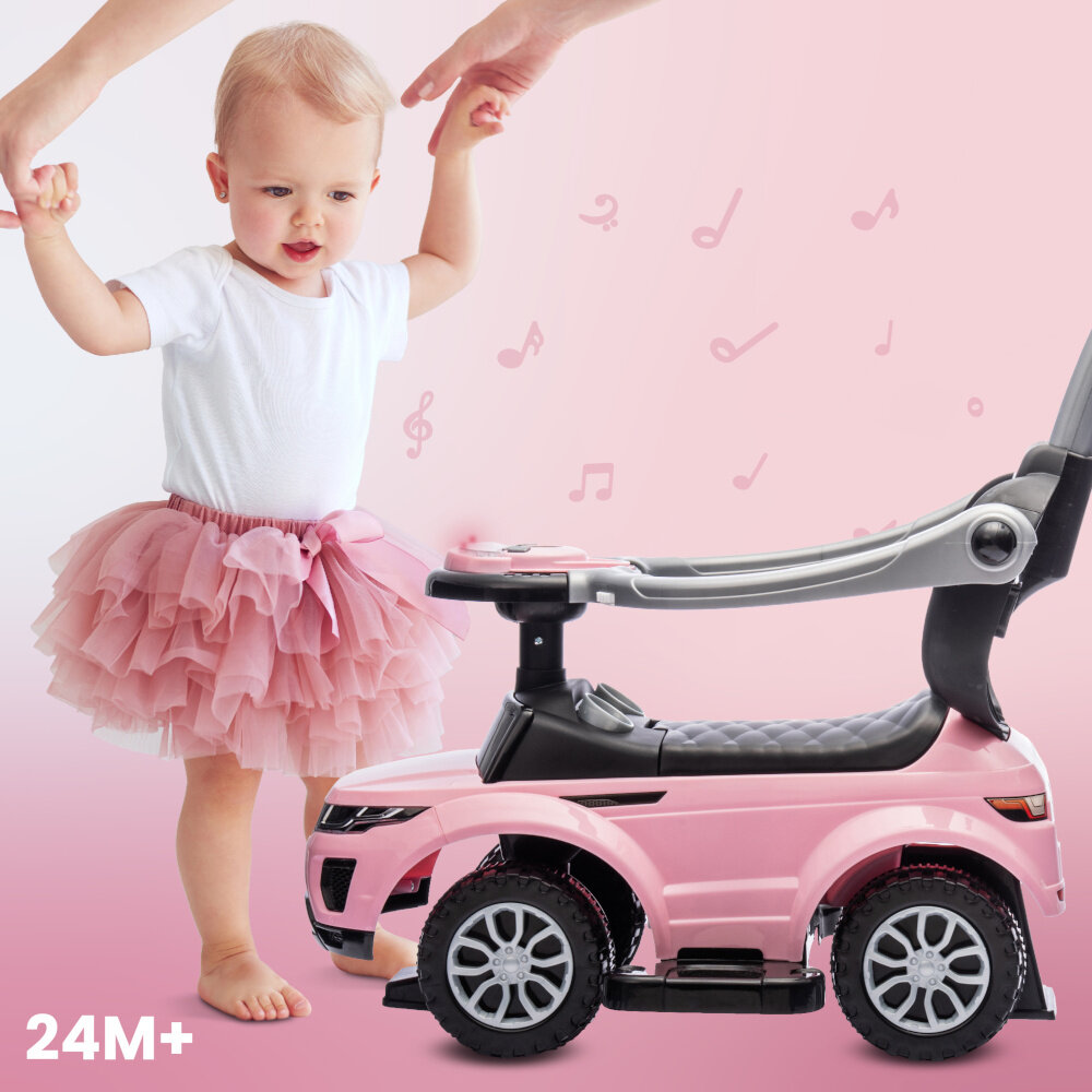 Na obrazie widoczny jest różowy jeździk z rączką oraz dziecko w białej koszulce i różowej spódniczce. W tle znajdują się różowe nutki, a w dolnym rogu widnieje napis \'24M+\'.