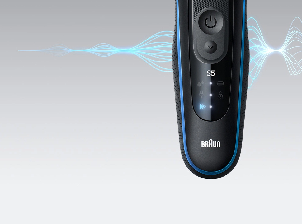 Detal maszynki do strzyżenia z falami dźwiękowymi, ilustrującymi jej działanie.