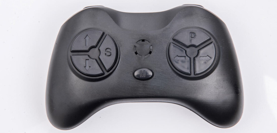 Czarny kontroler z dwoma okrągłymi przyciskami oznaczonymi symbolami strzałek i literami \'S\' oraz \'P\'. Na środku znajduje się mały okrągły przycisk z literą \'M\'.