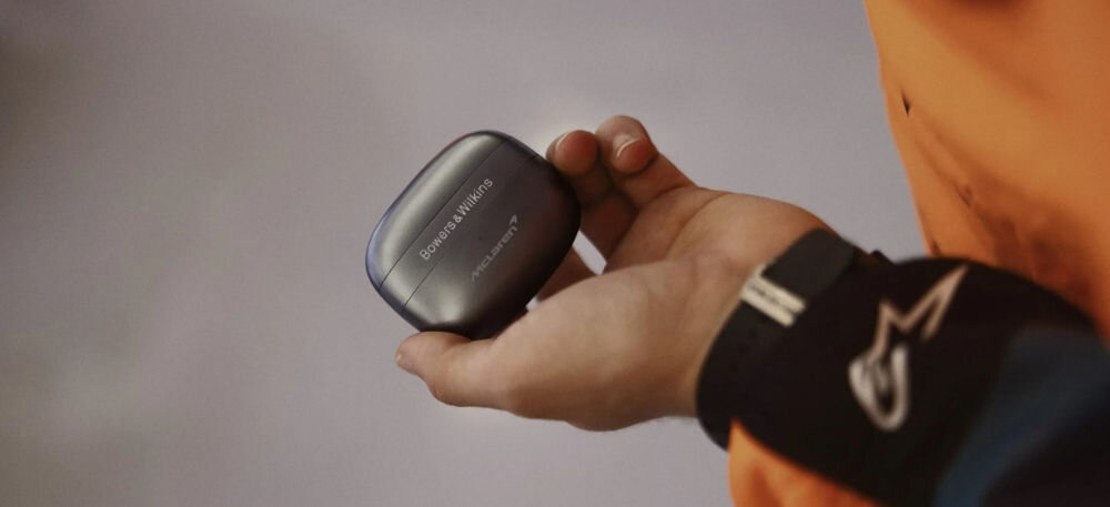 Słuchawki dokanałowe BOWERS & WILKINS PI8 McLaren ANC etui ładujące USB-C retransmisja dźwięku, osoba trzymająca etui w ręku