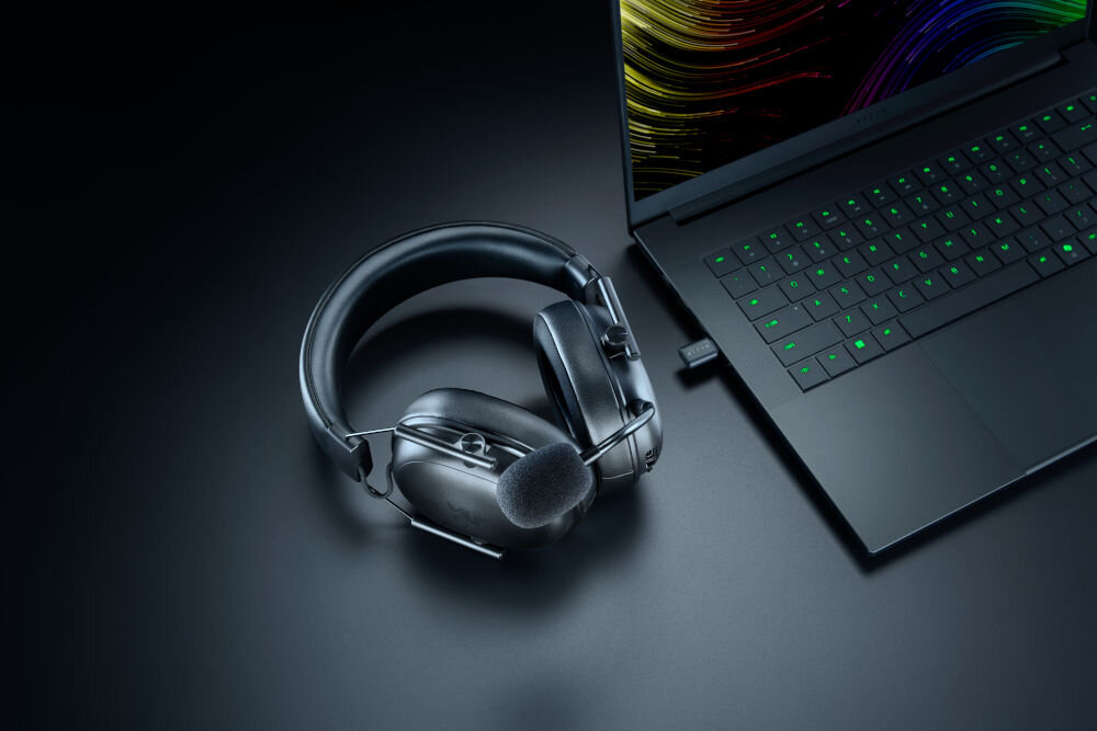 RAZER BlackShark V3 Pro THX Spatial Audio dźwięk przestrzenny gaming FPS 7.1.4, słuchawki leżące na biurku obok laptopa