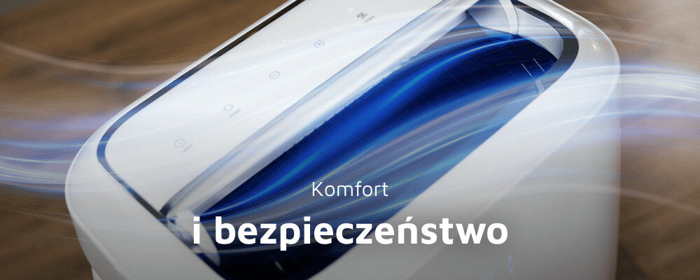 Zbliżenie na górną część białego klimatyzatora z niebieskim elementem. Na obrazie widoczny jest tekst: \'Komfort i bezpieczeństwo\'.