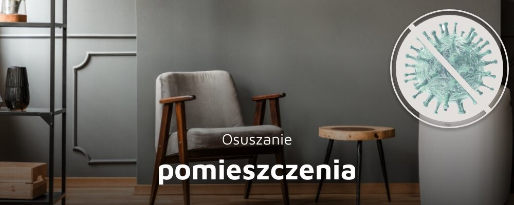 Wnętrze pokoju z szarym fotelem i drewnianym stolikiem na tle szarej ściany. Na obrazie widoczny jest napis \'Osuszanie pomieszczenia\' oraz symbol przekreślonego wirusa.