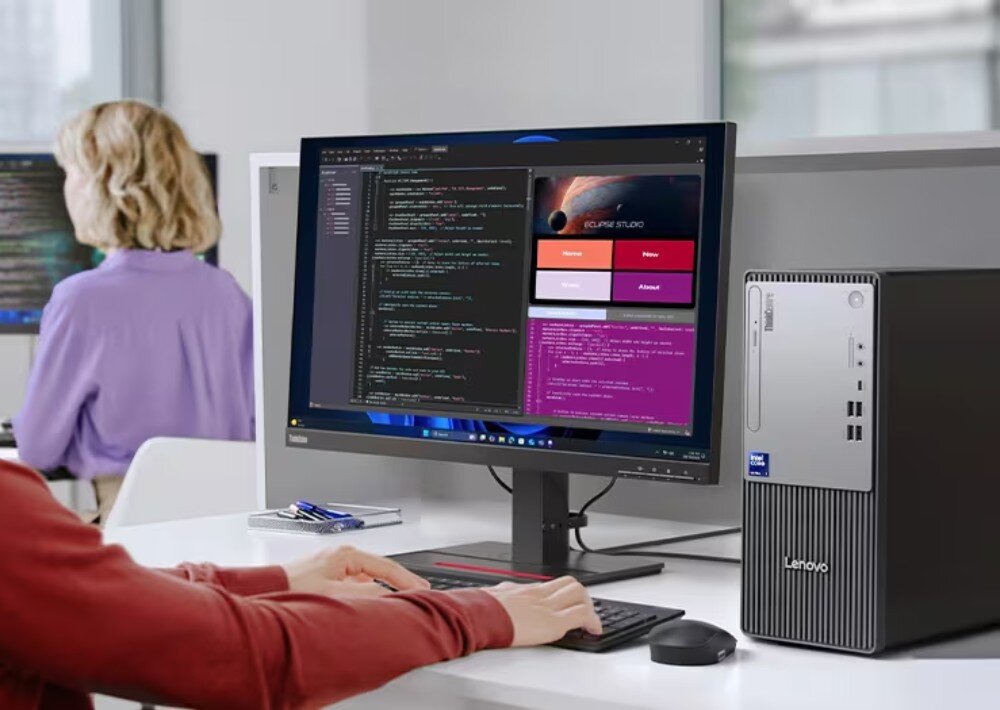 Komputer LENOVO ThinkCentre neo 50t Gen 6 Fotografia pracownika biurowego piszącego na klawiaturze przed monitorem, na którym wyświetlane są linie kodu programistycznego oraz okno podglądu aplikacji, obudowa, wielkość, miejsce na dyski