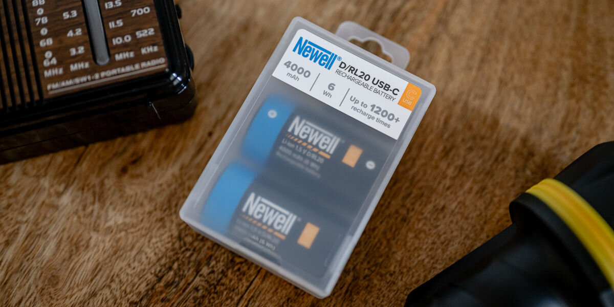 Akumulatorki NEWELL 21700 USB-C 5000 mAh (2 szt.), jakość, marka, doświadczenie, zaufanie, Dwa akumulatory Newell USB-C C/R14 przy starym aparacie fotograficznym, książkach