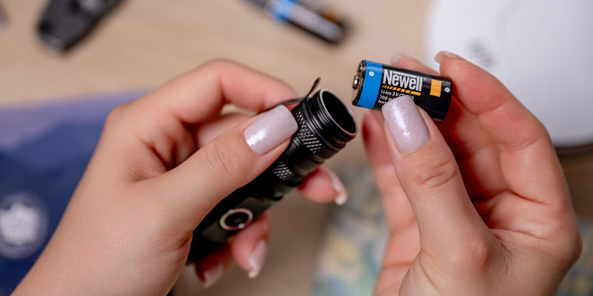 Akumulatorki NEWELL NL4206 CR123A USB-C 700 mAh (2 szt.), zastosowania, Li-ion, wszechstronność, mobilność, Dłoń wkłada Newell do latarki LED.