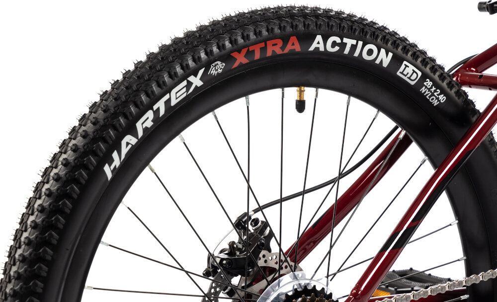 Rower młodzieżowy INDIANA X-Pulser 2.6 26 cale Czerwony zbliżenie na koło 26-calowe koła szeroki opony marki HARTEX dobra przyczepność aluminiowe obręcze zachowanie regularnego kształtu kół bezpieczna i komfortowa jazda stabilne trzymanie opony regularne sprawdzanie ciśnienia powietrza wartość na bocznej części opony