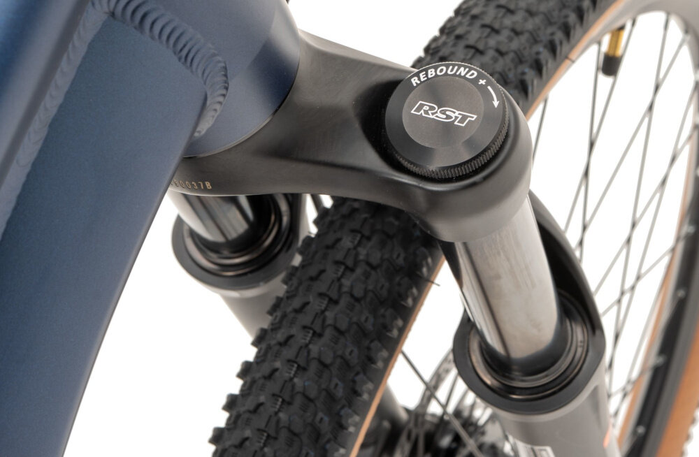 Rower górski MTB INDIANA Dirt Jump 3.0 M13 26 cali męski Granatowo-złoty zbliżenie na amortyzator widok z góry rower typu hardtail przedni amortyzator RST o konstrukcji sprężynowej tłumi wstrząsy i drgania komfort i stabilność jazda staje się płynniejsza dłonie i nadgarstki są mniej obciążone trwałość sprawne działanie