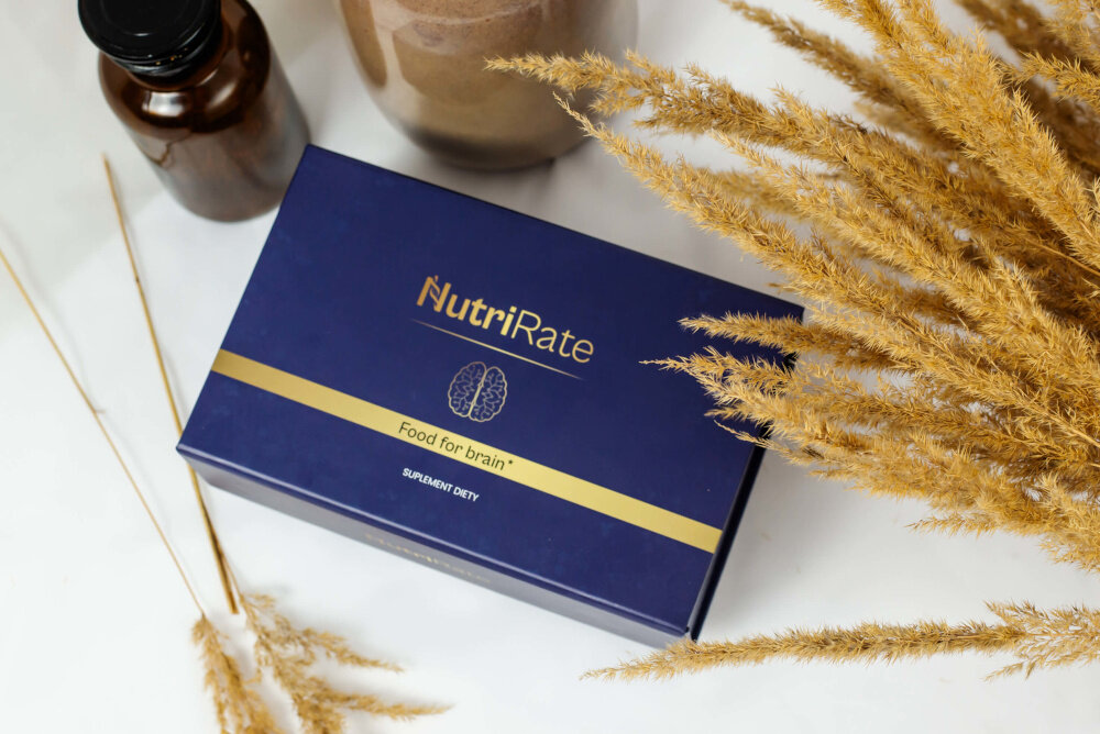 Suplement diety NUTRIRATE FoodforBrain 2 x 30 saszetek białe podłoże na podłożu zamknięte pudełko wokół buteleczki kwiaty naturalne wsparcie mózgu koncentracja regulacja układu nerwowego