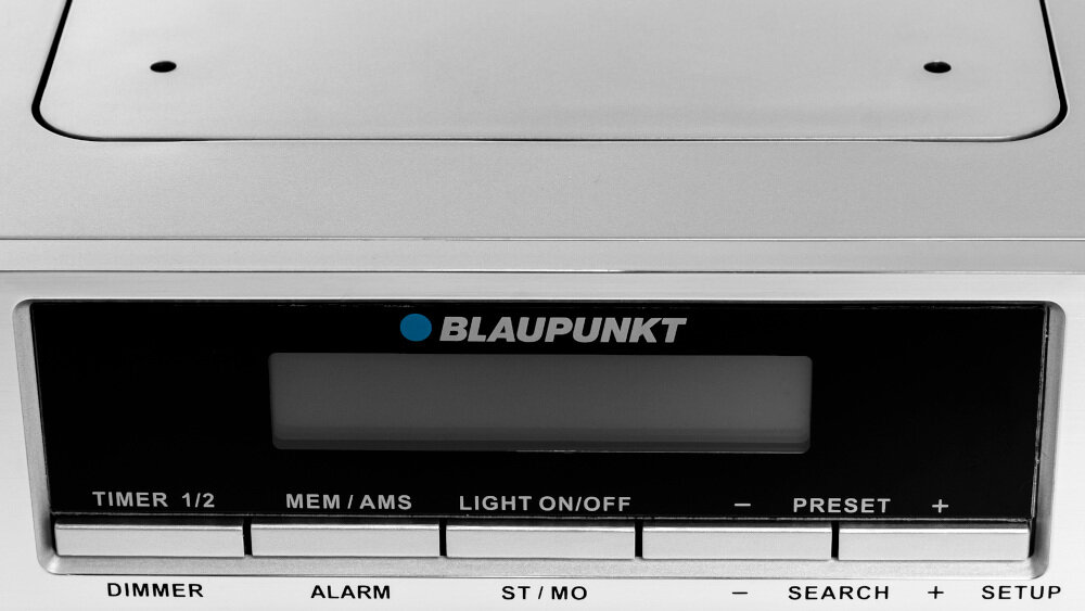 Na obrazie widoczny jest panel radia z logo BLAUPUNKT oraz przyciskami: TIMER 1/2, MEM/AMS, LIGHT ON/OFF, PRESET +, DIMMER, ALARM, ST/MO, SEARCH +, SETUP.