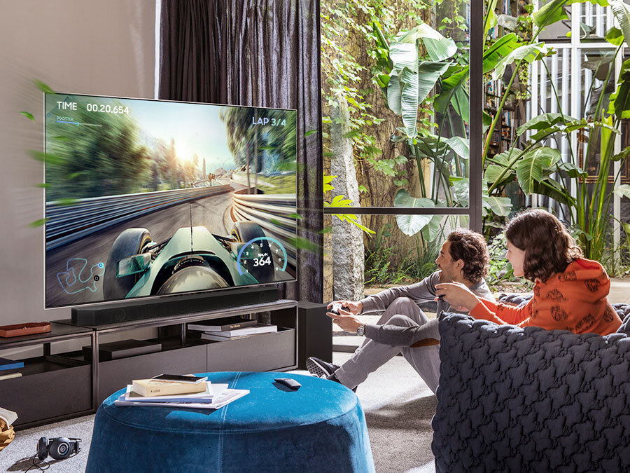 phplrqai3 pl-feature-be-a-part-of-the-game-with-dynamic-sound-531142705 Para grająca na konsoli w grę wyścigową. HW-Q700B