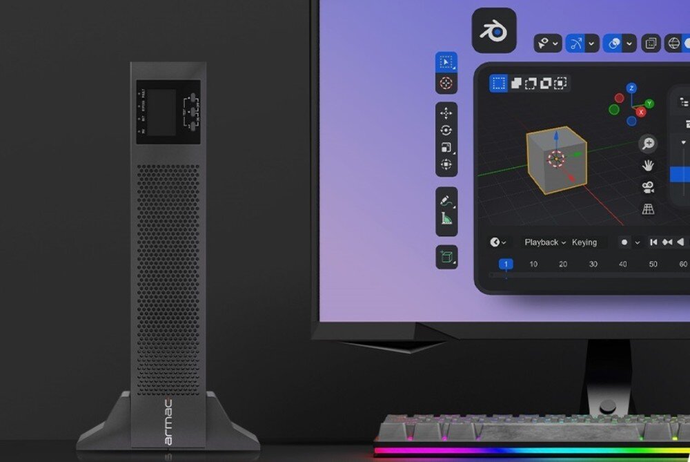 Zasilacz UPS ARMAC Office Rack On-Line PF1 Zasilacz awaryjny UPS stojący w pionie obok monitora komputerowego z otwartym programem do grafiki trójwymiarowej oraz klawiatury