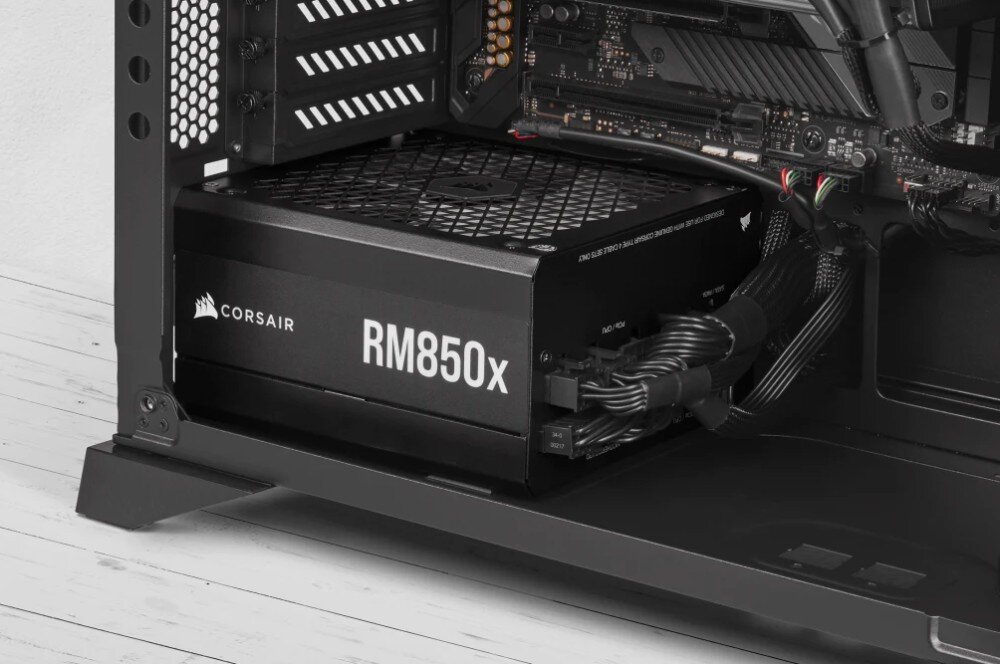Komputer XQUANTUM Creator GeForce RTX Studio RS-R7-5070TIWP Zasilacz komputerowy wewnątrz obudowy z widocznym napisem 'Corsair RM750x' na czarnym panelu bocznym, zasilacz, moc, sprawność, certyfikat