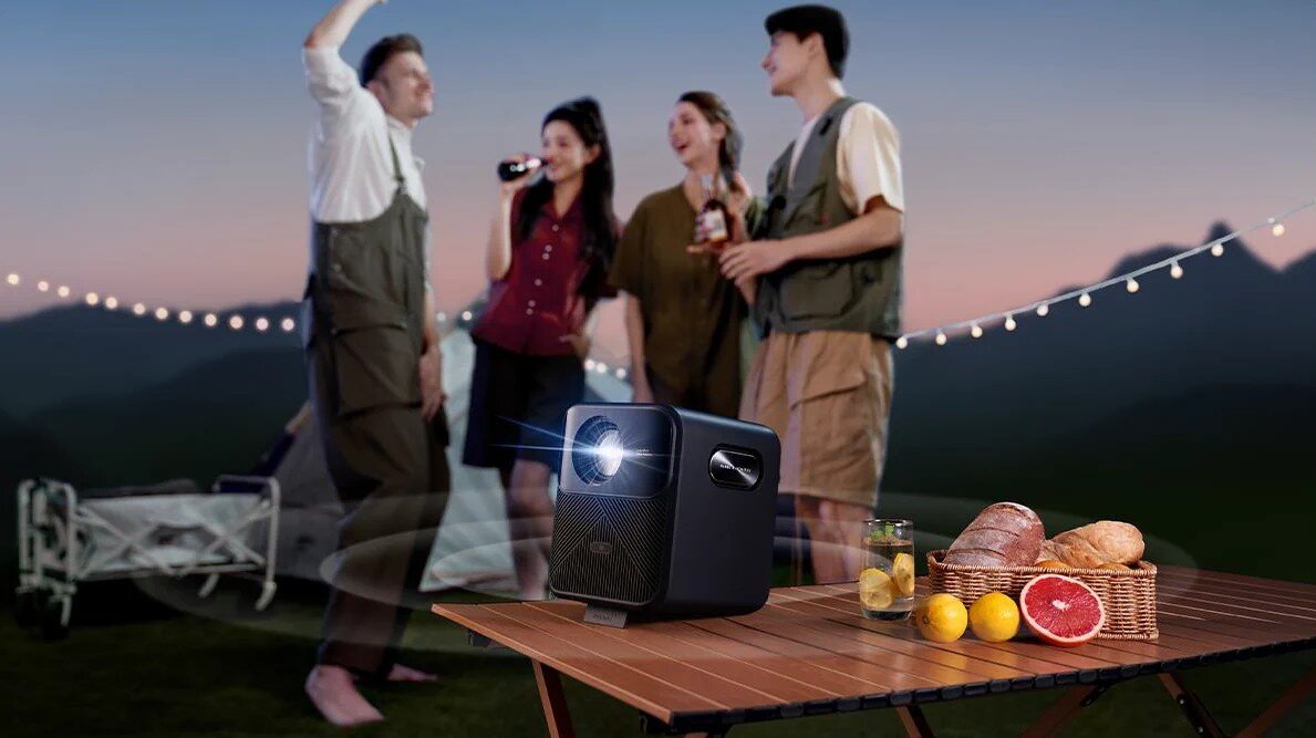 Projektor WANBO Mozart 1 Pro - Dobra jakość dźwięku, ludzie stojący obok projektora, projektor stojący na stoliku