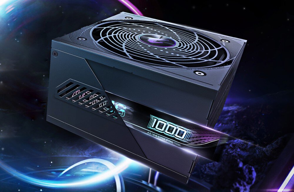 Komputer MAD DOG GeForce RTX5090 DLSS 4 Reflex Edition 2 Powered by Gigabyte C500-A05WR64WH Czarny zasilacz z dużym wentylatorem na górze i podświetlanym napisem '1000' na bocznym panelu, umieszczony na tle przestrzeni kosmicznej z wirującymi kolorowymi smugami światła, zasilacz, moc, sprawność, zabezpieczenia