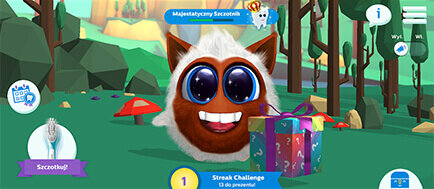 Animowana postać z dużymi oczami i uśmiechem znajduje się na tle lasu, obok kolorowego pudełka z kokardą. Widoczny jest tekst: \'Majestatyczny Szczotnik\', \'Szczotkuj!\', \'Streak Challenge 1 dzień przemuł\'.