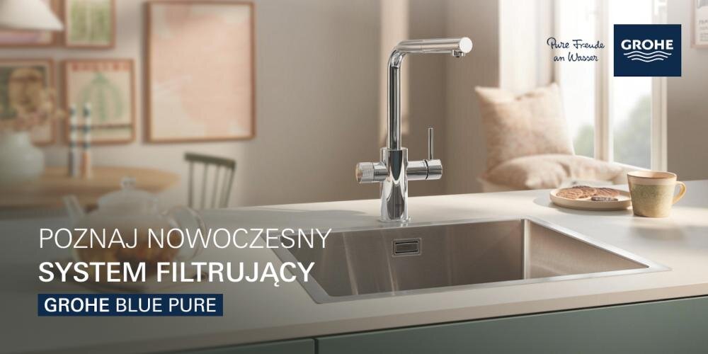 Na obrazie widoczna jest chromowana bateria kuchenna zamontowana przy zlewie. Tekst na obrazie: \'POZNAJ NOWOCZESNY SYSTEM FILTRUJĄCY GROHE BLUE PURE\'.
