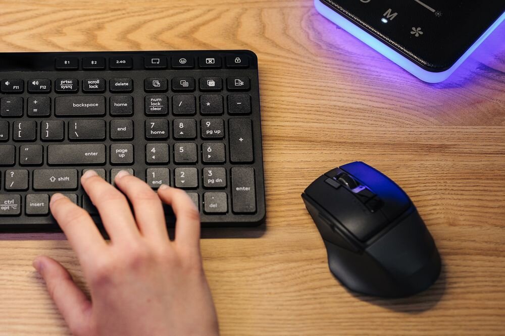A4TECH Fstyler FB45CS Air2 technologii cichych kliknięć bez rozpraszających dźwięków - myszka na drewnianym blacie obok klawiatury