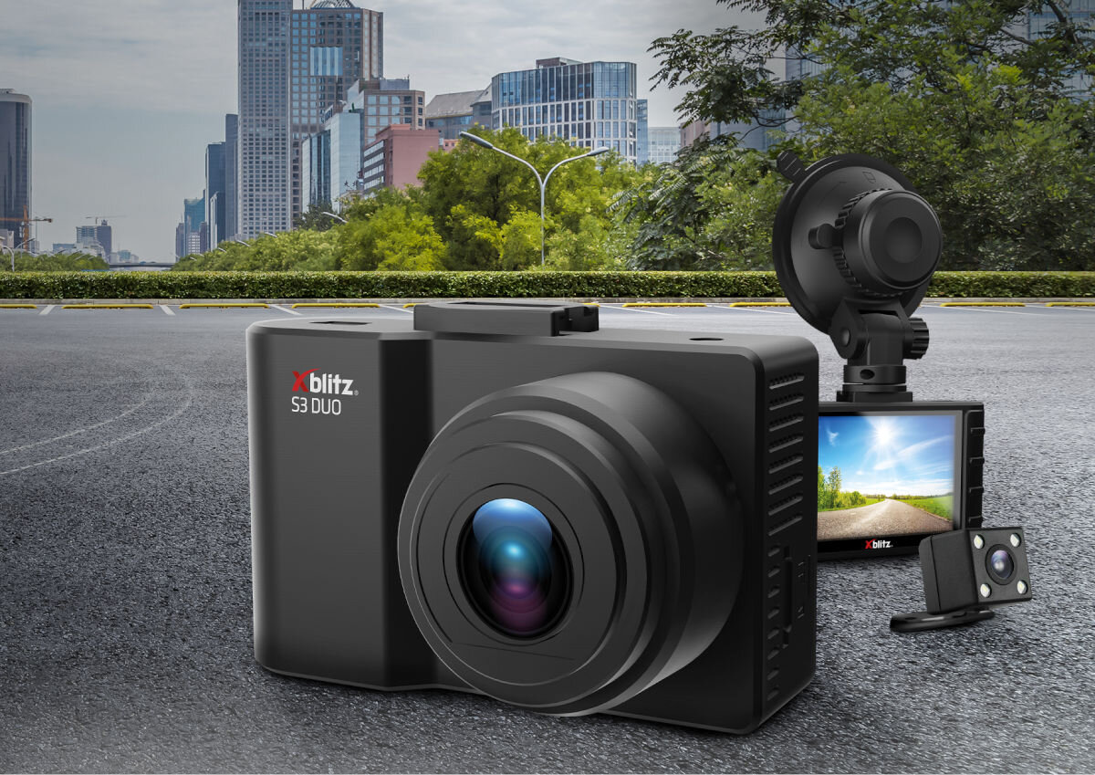 Na obrazie widoczny jest wideorejestrator z dużym obiektywem, obok którego znajduje się mniejszy ekran z wyświetlanym krajobrazem. Na urządzeniu widnieje logo \'xblitz S3 DUO\'.