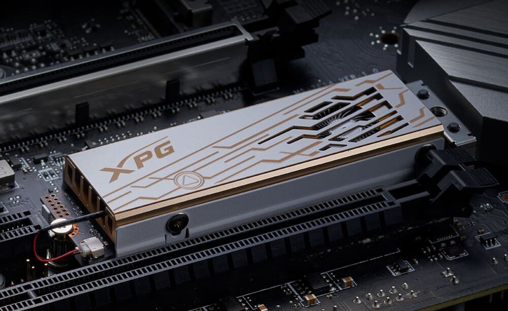 Komputer MAD DOG GeForce RTX5090 DLSS 4 Reflex Edition 2 DEEPCOOL-A15WR64WP Dysk SSD w obudowie z metalicznym radiatorem w kolorze srebrno-złotym z wycięciami wentylacyjnymi, zamontowany na płycie głównej, dysk, pojemność, szybkość, trwałość