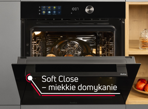 Czarny piekarnik elektryczny z otwartymi drzwiczkami, na których widnieje napis \'Soft Close – miękkie domykanie\'. Wewnątrz piekarnika znajdują się pieczone potrawy, a na panelu sterowania widoczny jest wyświetlacz z ikonami i godziną 10:07.