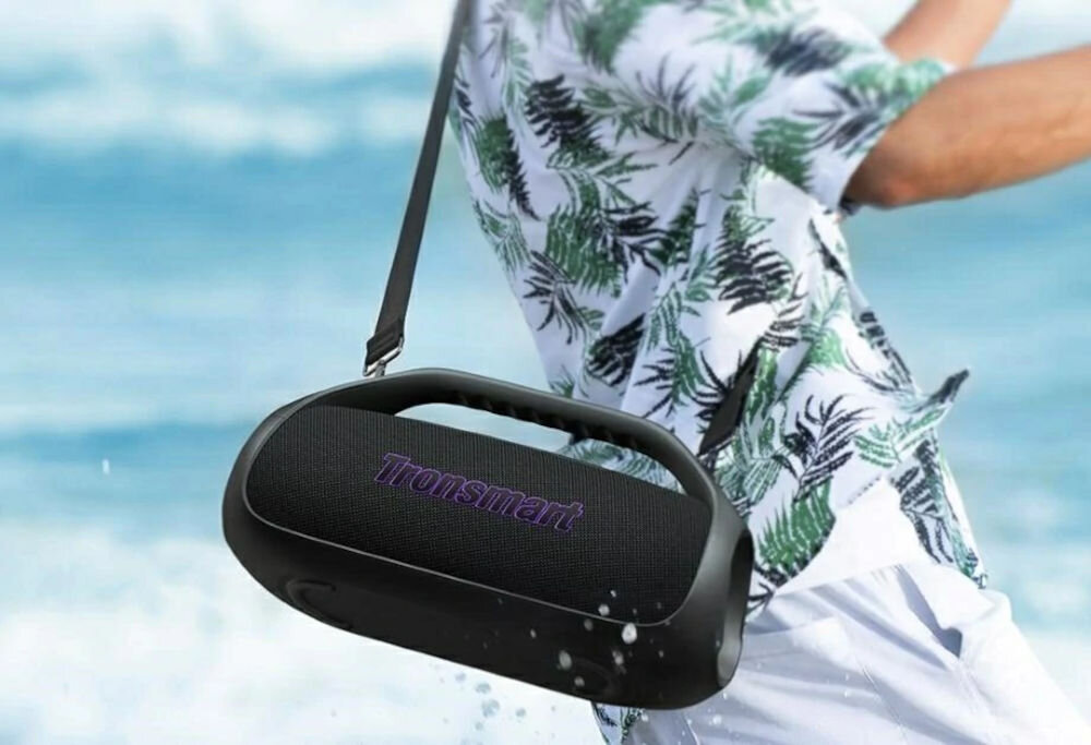 Głośnik mobilny TRONSMART Bang 2 — ultraprzenośna konstrukcja, pasek i uchwyt, łatwe przenoszenie, osoba niosąca głośnik na pasku na ramieniu
