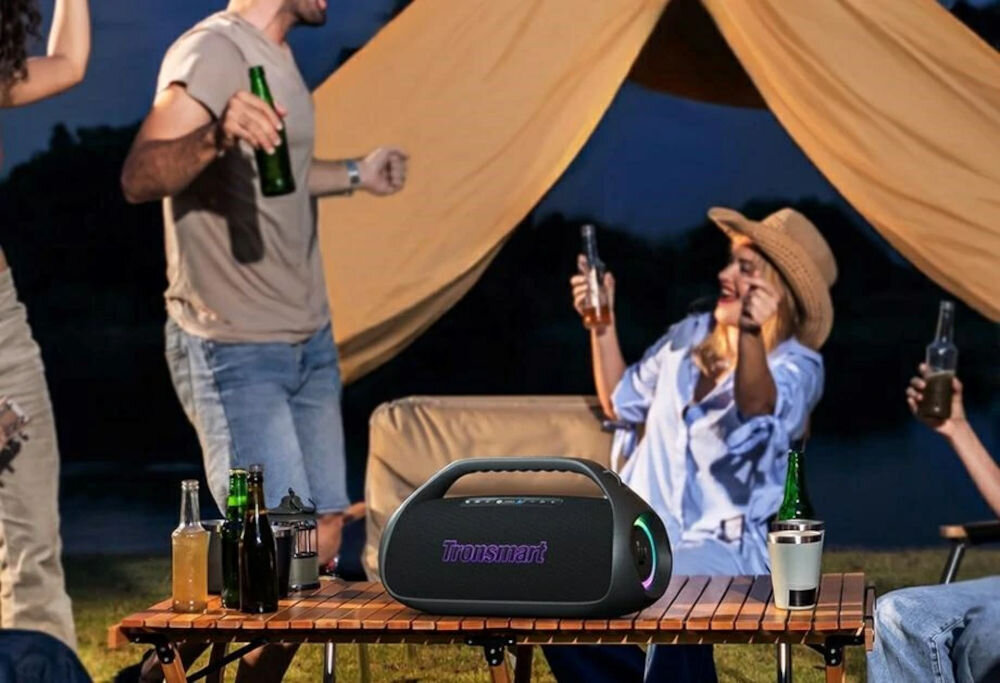 Głośnik mobilny TRONSMART Bang 2 — podwójne połączenie urządzeń, odtwarzanie muzyki na zmianę, osoby bawiące się w plenerze w rytm muzyki wydobywającej się z głośnika