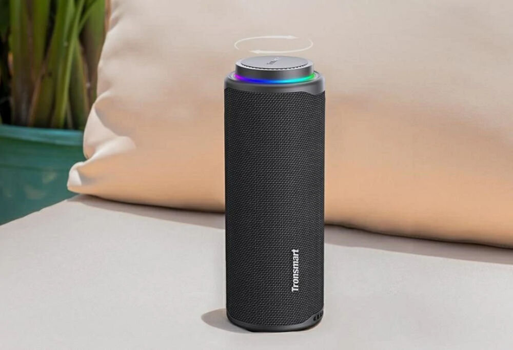 Głośnik TRONSMART T8 z intuicyjnym pokrętłem głośności i eleganckim designem, Głośnik T8 na jasnej, skórzanej sofie z wyróżnionym pokrętłem