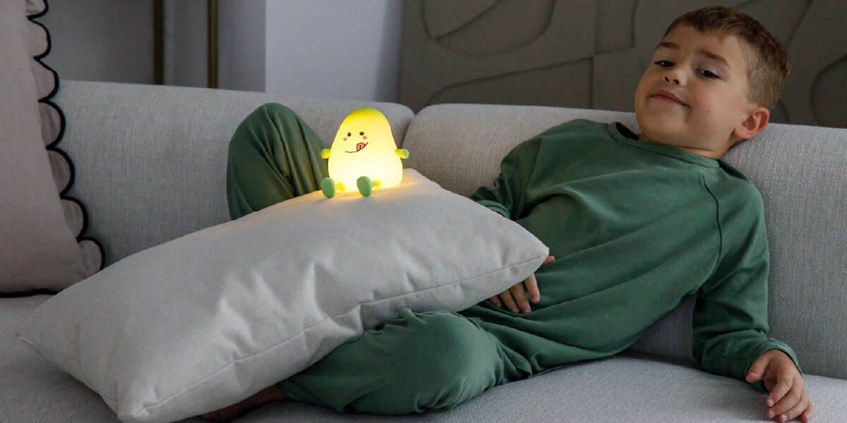 Lampka nocna INNOGIO GIOmango Mango GIO-149, ciepłe, białe, światło, poziomy, jasność, dziecko leży na kanapie, na poduszce lampka nocna giomango