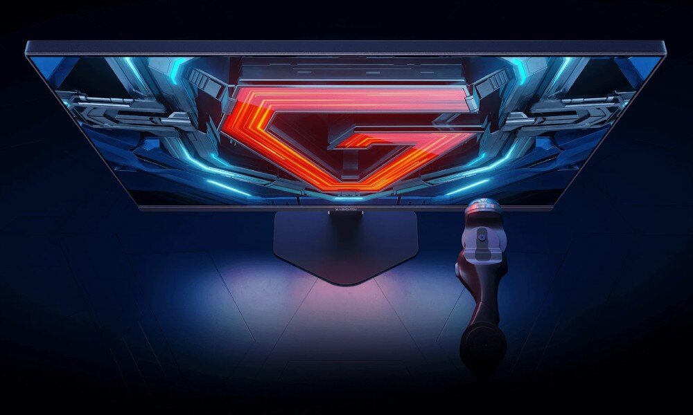 Monitor XIAOMI G27i Widok z góry na monitor wyświetlający czerwoną literę 'G' wpisaną w sześciokąt na mechanicznym tle, obsługa HDR, jakość