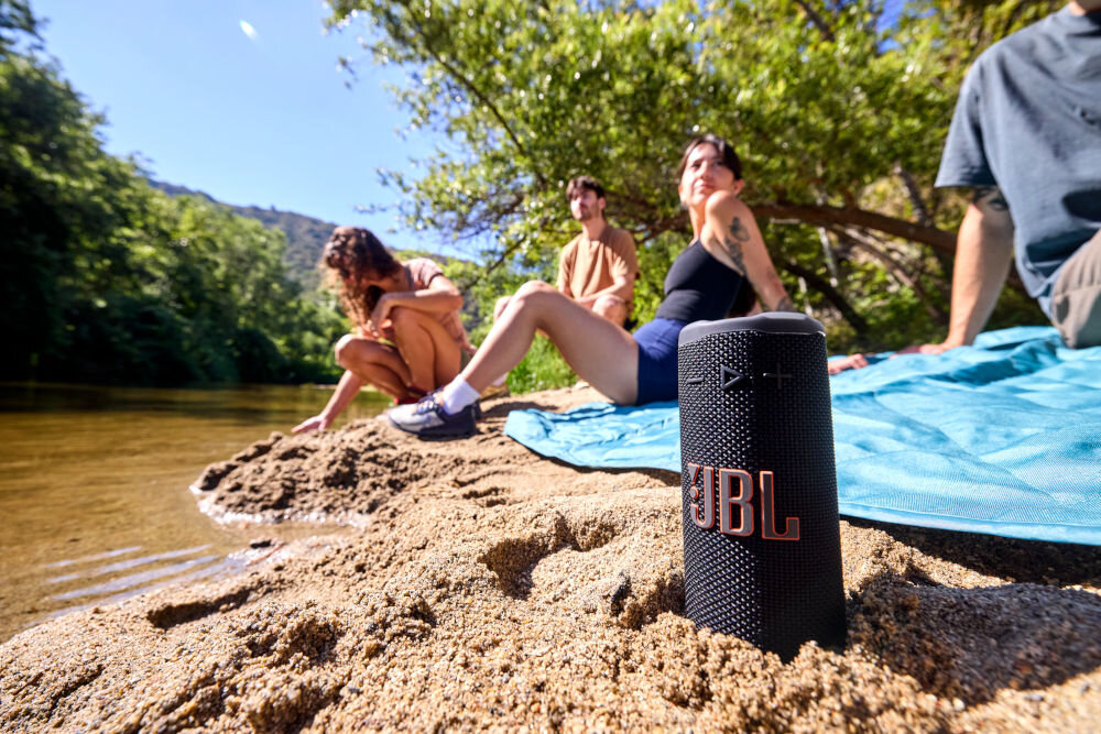 JBL Grip długi czas odtwarzania 14 godzin Playtime Boost - głośnik częściowo zakopany w piasku na plaży