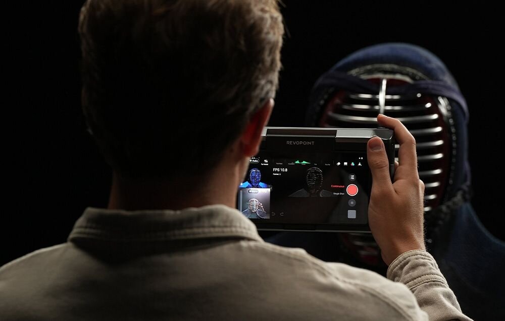 Skaner 3D Revopoint Miraco mężczyzna skanujący osobę w ciemnym kapturze i masce waga solidna obudowa mobilność