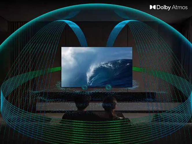 Na obrazie widać telewizor wyświetlający obraz fali na morzu, z efektami dźwiękowymi Dolby Atmos przedstawionymi jako kolorowe linie wokół ekranu. W prawym górnym rogu znajduje się logo \'Dolby Atmos\'.