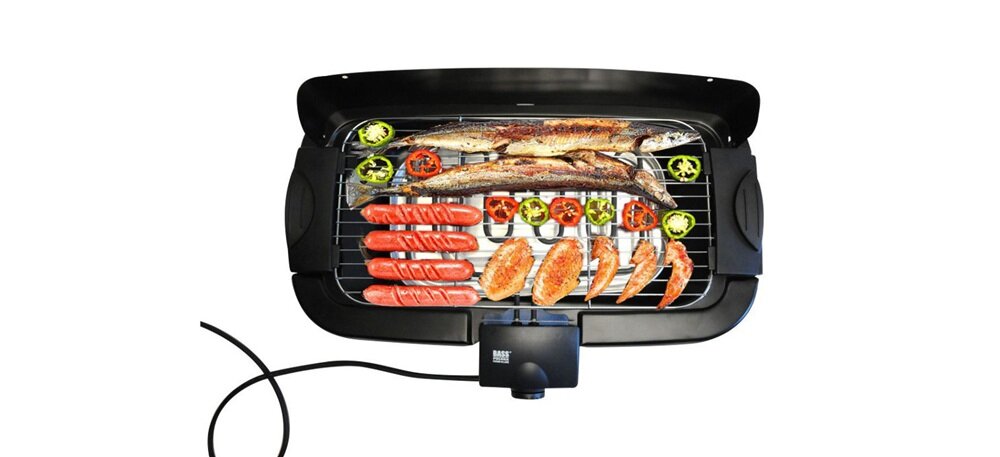 Grill elektryczny z różnorodnymi potrawami, w tym rybami, kiełbaskami, kurczakiem i warzywami. Na urządzeniu widoczne jest logo \'BASS POLSKA\'.
