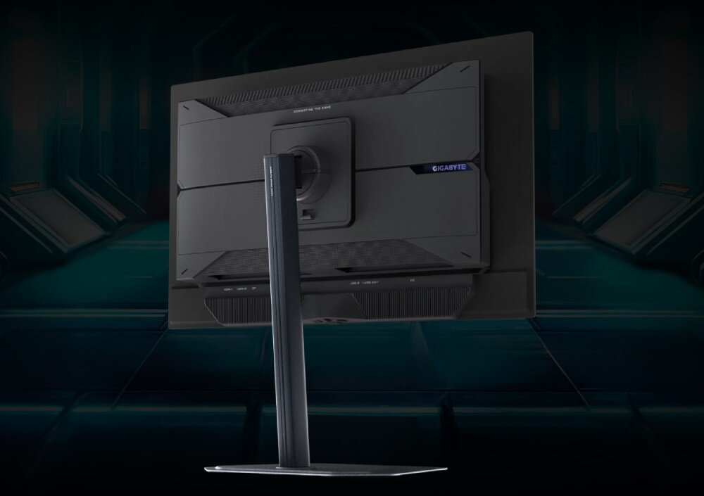 Monitor GIGABYTE MO27Q2 Tylna część monitora z widocznym uchwytem do regulacji wysokości i napisem 'GIGABYTE' z boku obudowy, podstawa, regulacja, ergonomia