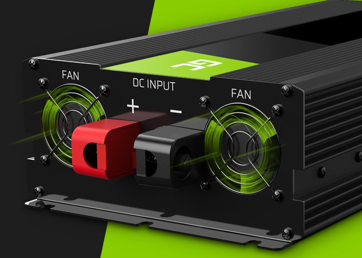 Obraz przedstawia przetwornicę z widocznymi dwoma wentylatorami i złączami DC INPUT oznaczonymi jako \'+\' i \'-\'. Na górze urządzenia znajduje się zielone logo z literą \'A\'.