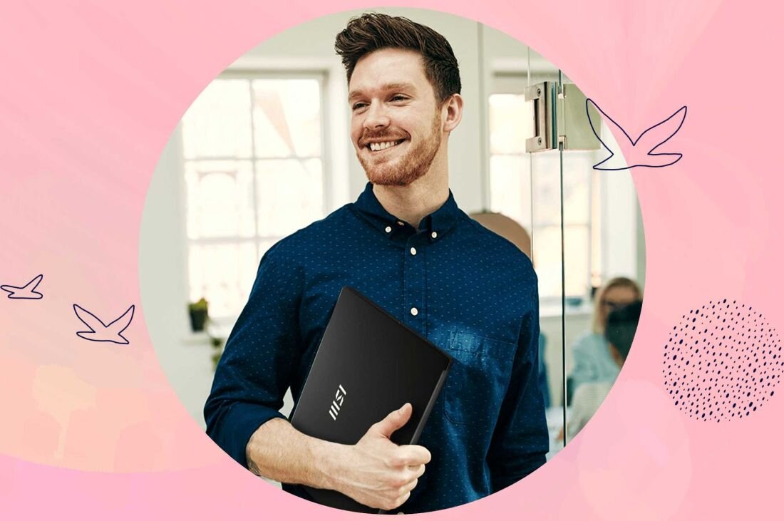 Uśmiechnięty mężczyzna w niebieskiej koszuli trzymający lekki laptop MSI Modern w nowoczesnym biurze, portabilność i mobilność - Lekki laptop   