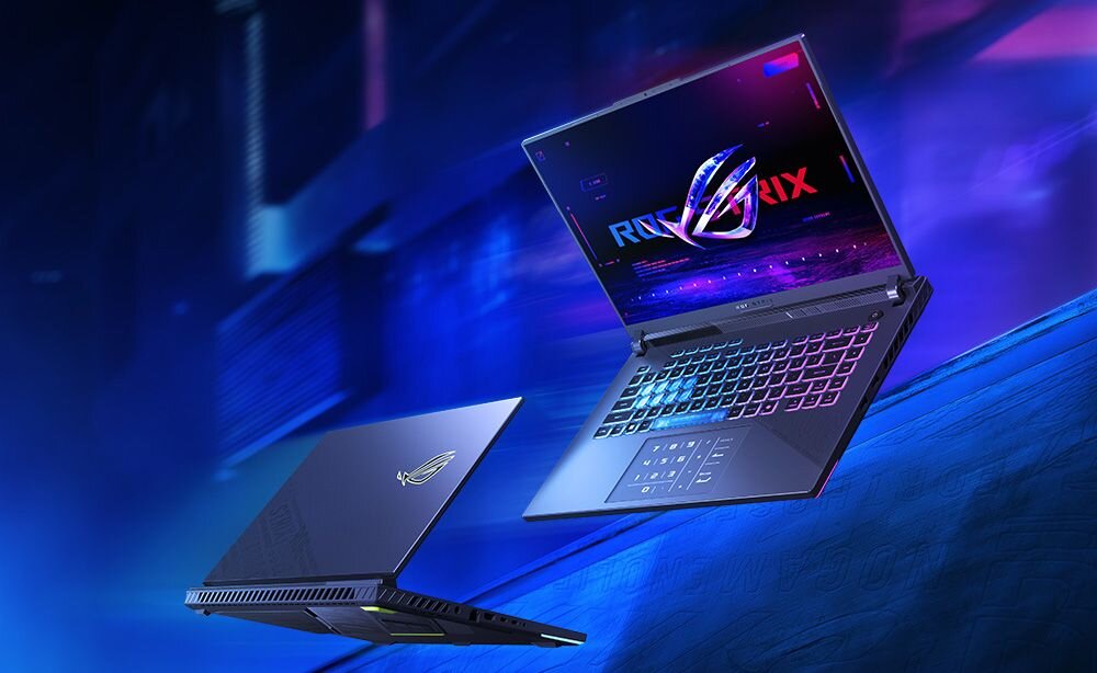 Laptop gamingowy ASUS ROG Strix z kolorowym RGB podświetleniem obudowy i logo ROG lewitujący na niebieskim tle z efektami świetlnymi  